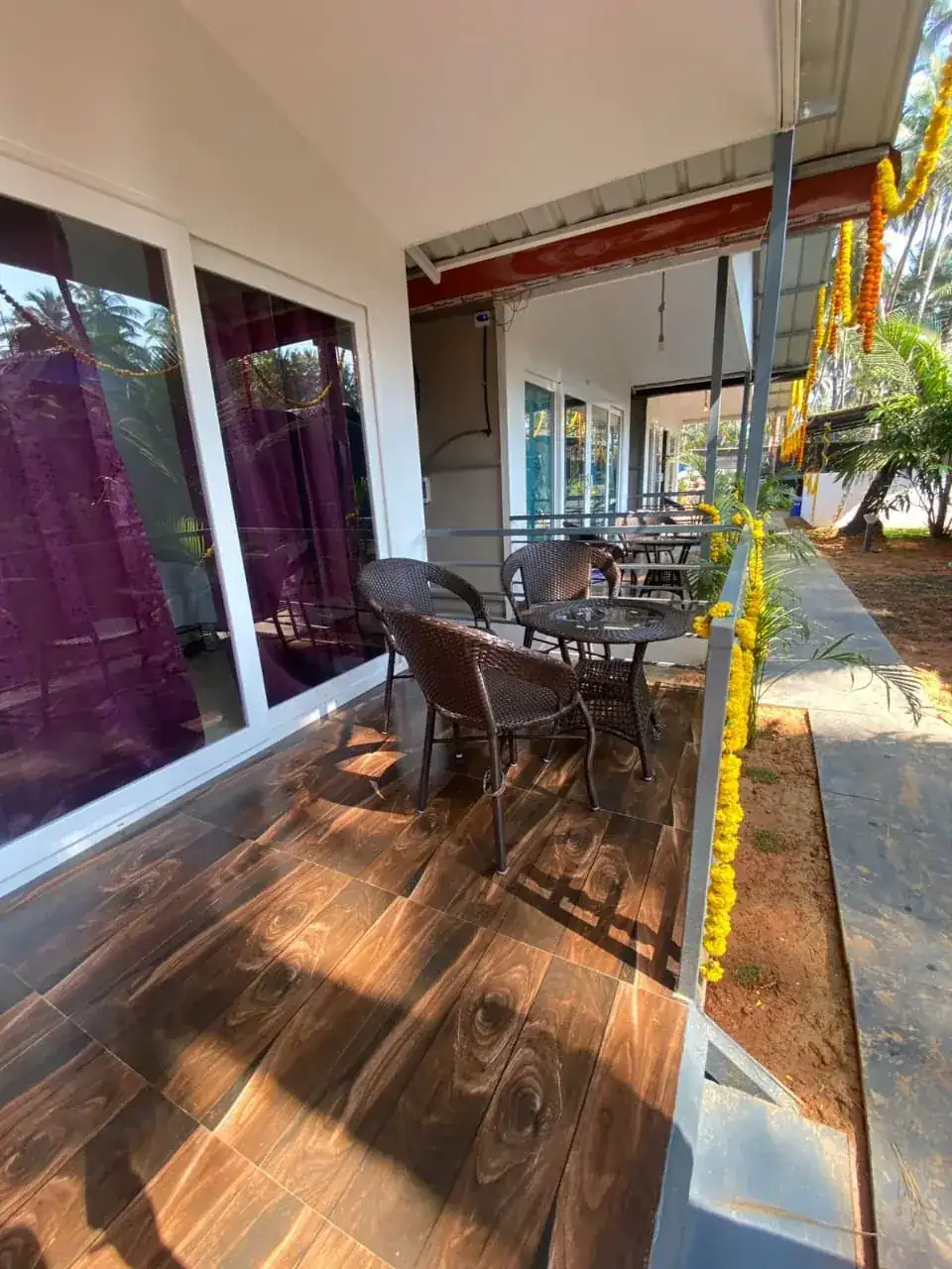 Covered veranda seating area at Saffron Sun Palolem beside the guest rooms
