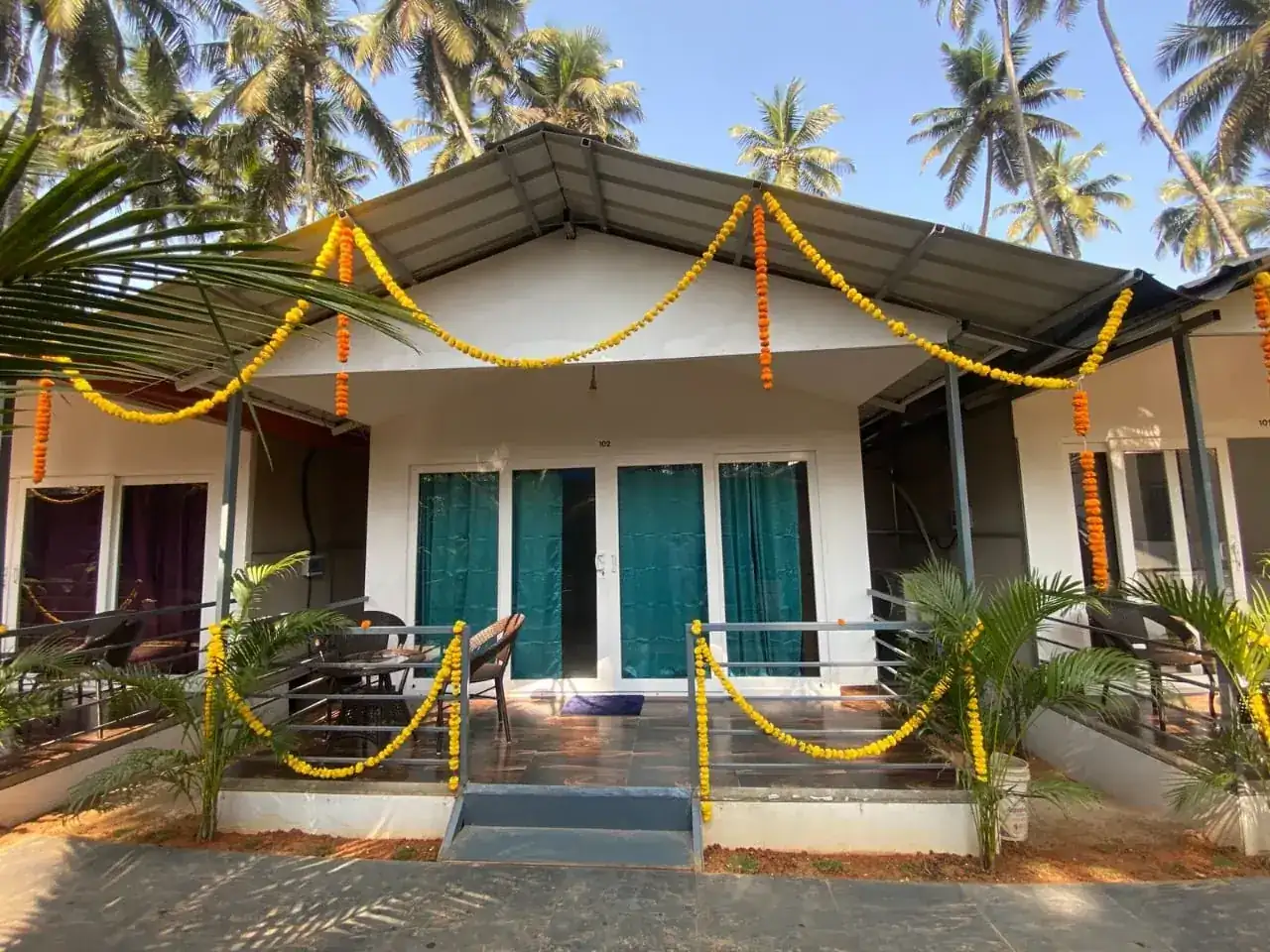 Front exterior of Saffron Sun Palolem with decorated entrance and tropical palms