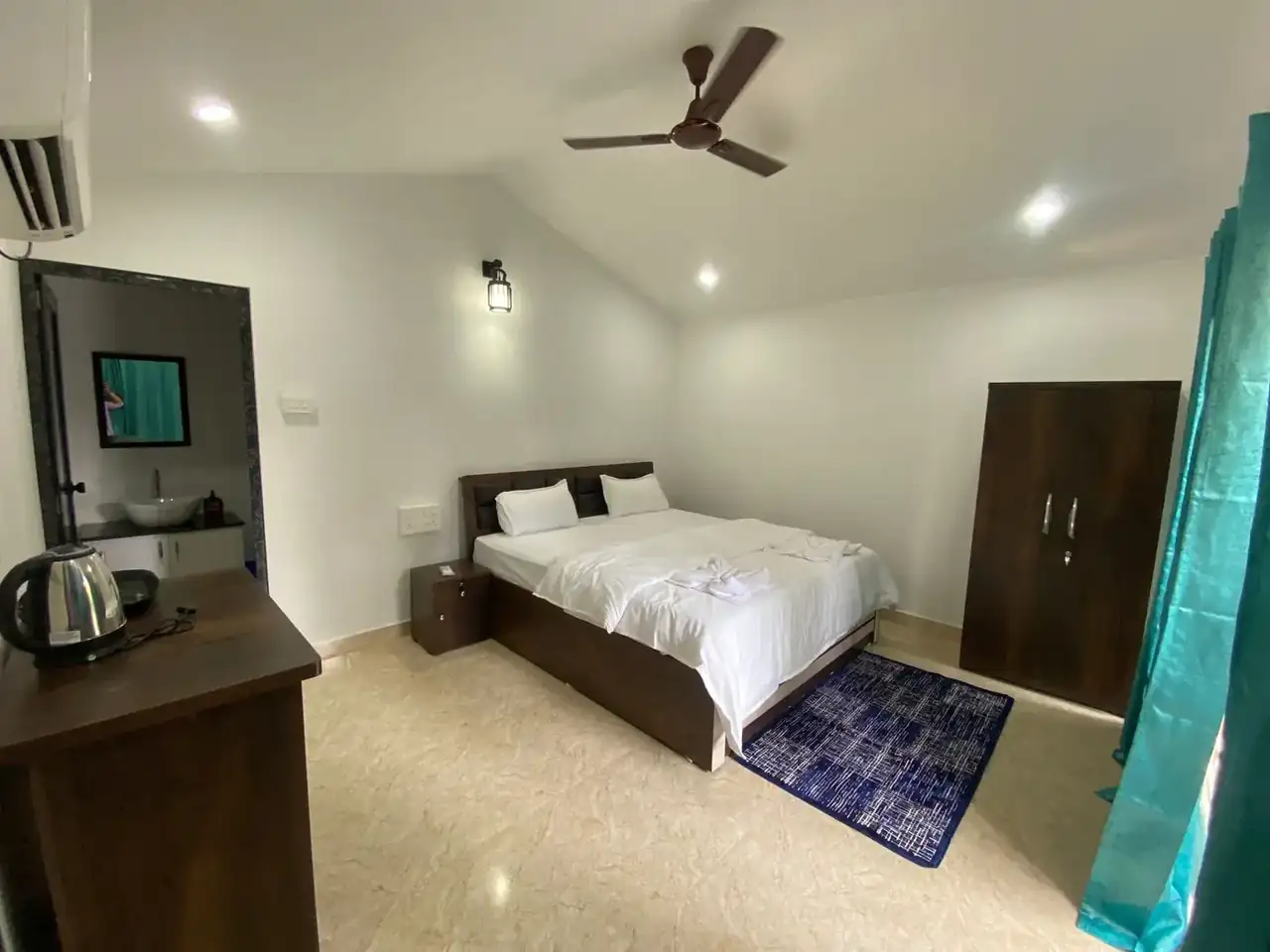 Saffron Sun Palolem guest room with double bed, seating, mirror and balcony door